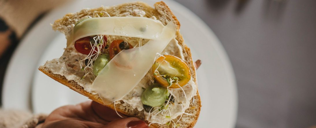 Bruschetta de pan masa madre con dip de salmón, tomates cherry, alfalfa y lascas de parmesano